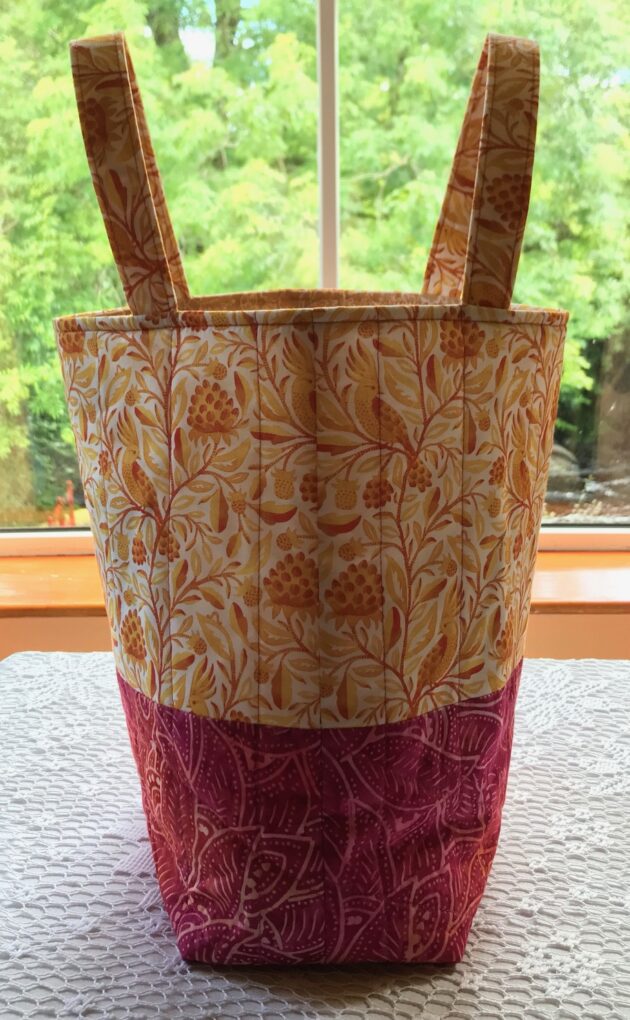The cockatoo features on this colourful quilted tote bag in shades of raspberry, yellow and orange