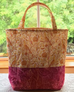 The cockatoo features on this colourful quilted tote bag in shades of raspberry, yellow and orange