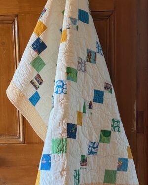 yellow baby quilt with images of small animals at play