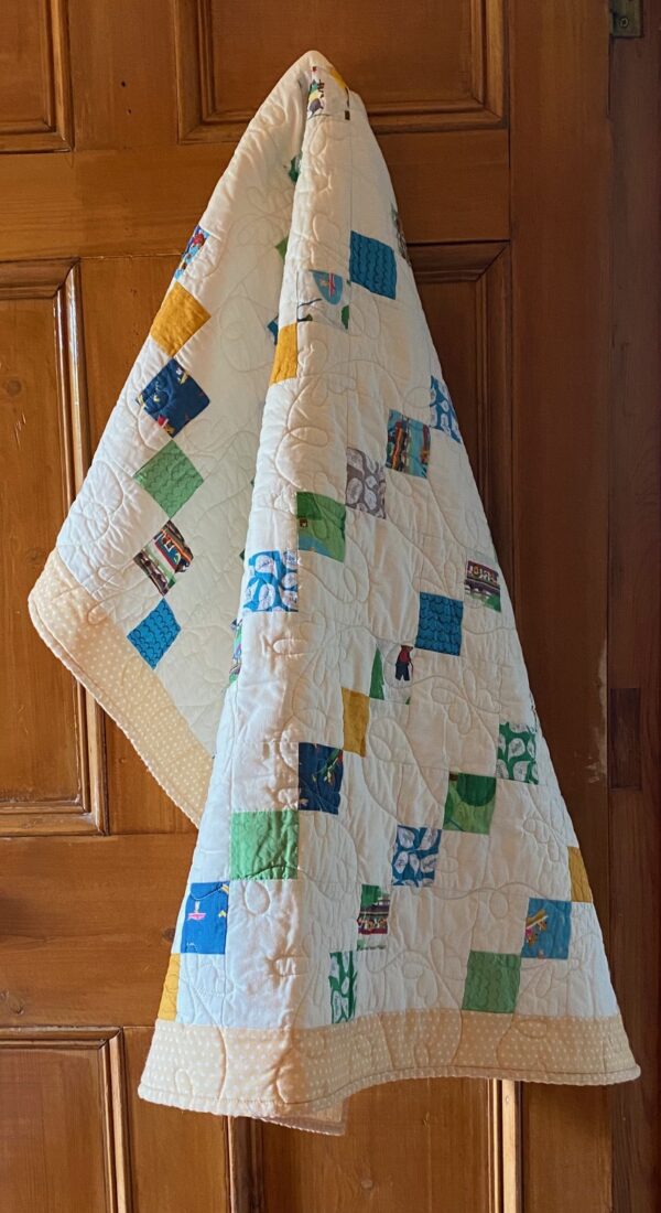 yellow baby quilt with images of small animals at play