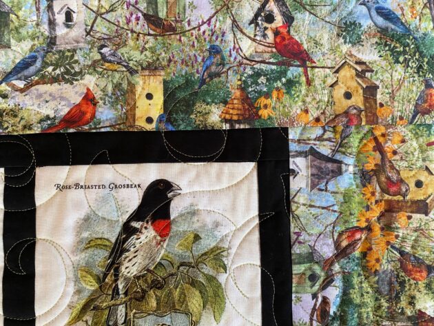 colourful fabric of a forest of birds on branches and in birdhouses