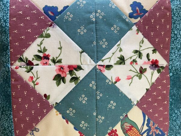 detail of a vintage-look patchwork cushion made with Laura Ashley fabric