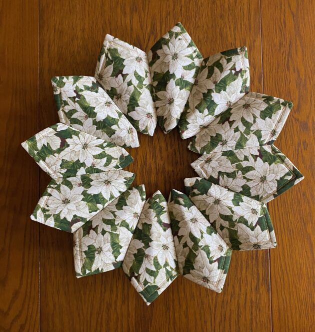 the back side of a fabric Christmas poinsettia wreath showing the beautiful white poinsettia fabric