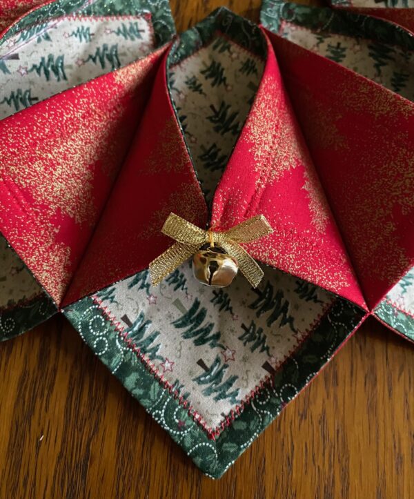 A detailed look at one of the sections of the Christmas Tree Wreath showing the gold metallic bow and jingle bell