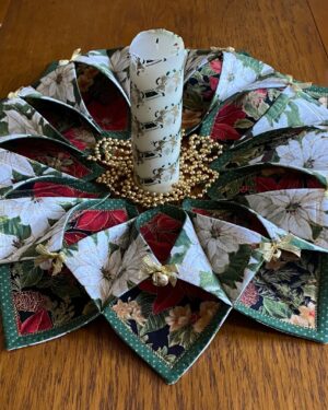 beautiful Christmas table wreath made with red and white poinsettia fabrics, metallic bows and jingle bells