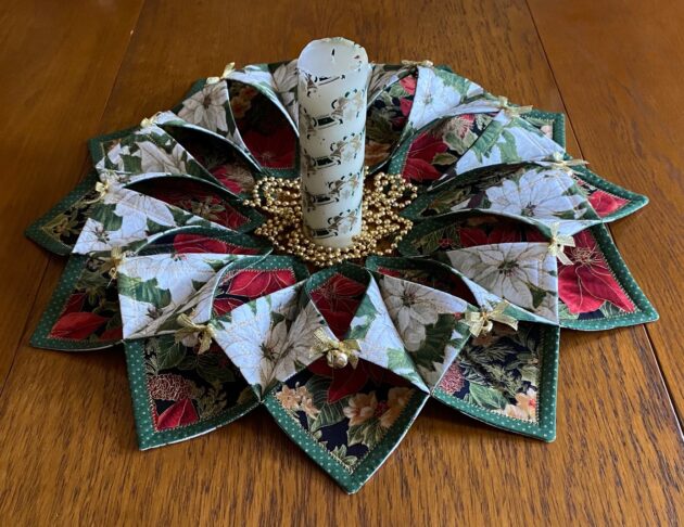 beautiful Christmas table wreath made with red and white poinsettia fabrics, metallic bows and jingle bells