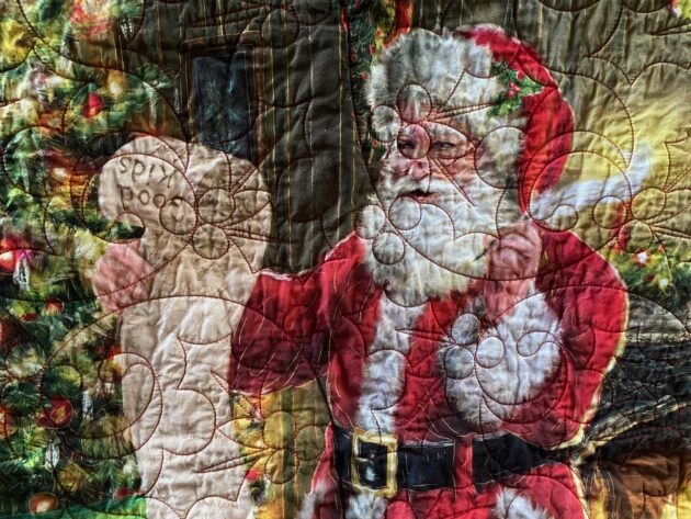 Detail of a Christmas throw quilt featuring Santa Claus checking his list