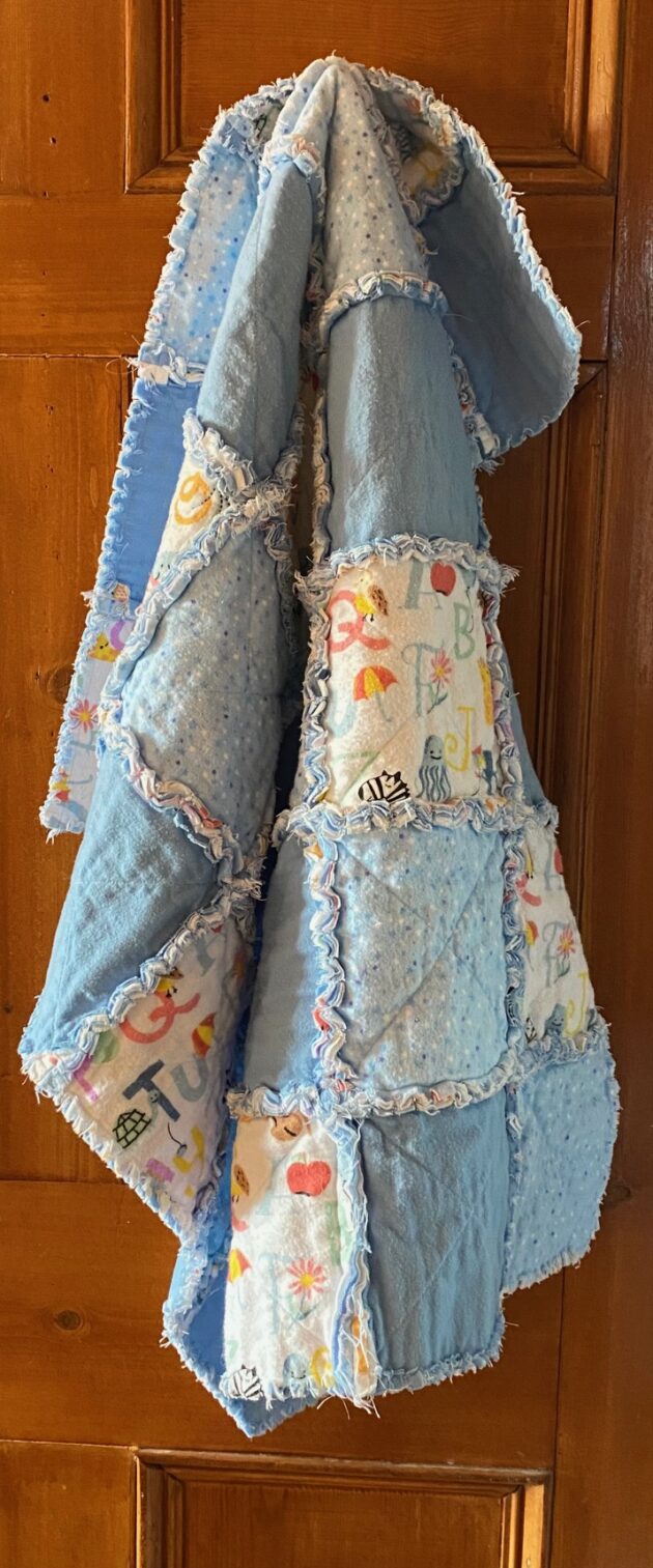 a small rag quilt in blue fabrics for a baby boy