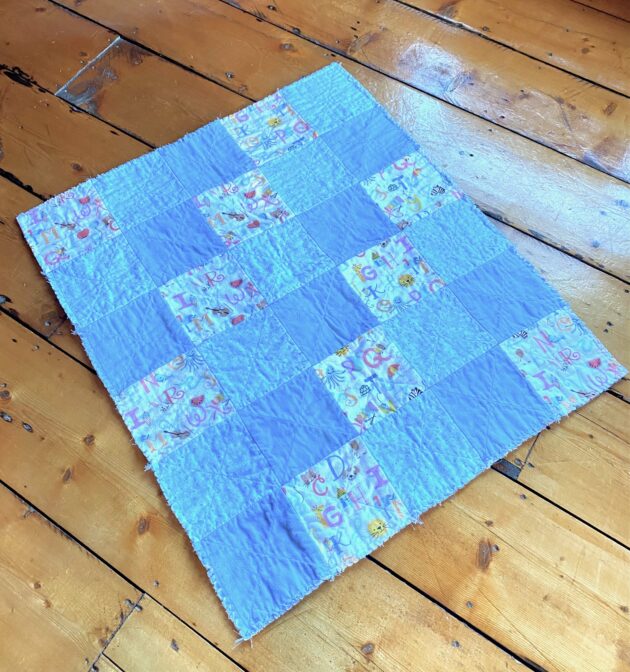 view of the back of a small rag quilt for a baby boy