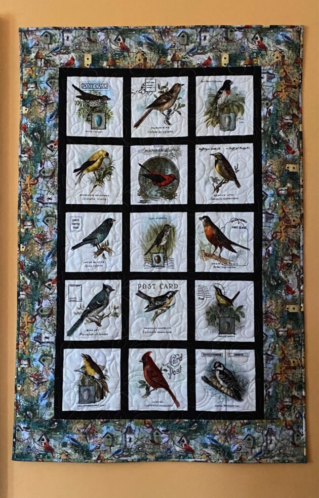 a quilted wall hanging depicting songbirds of North America