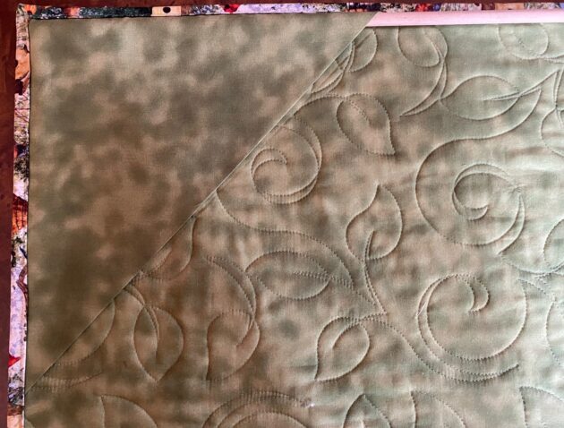 the back side of a wall hanging showing one of the hanging corners with a dowel inserted