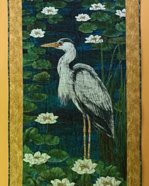 a grey heron standing among water lilies and watching for his next catch