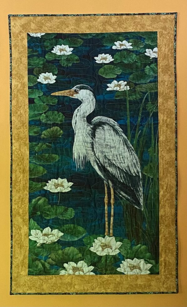 a grey heron standing among water lilies and watching for his next catch