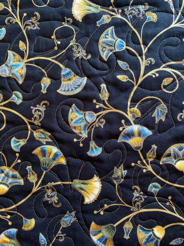 Quilted blue and gold gingko leaves on vines on a black background