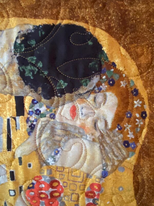 Close-up of a quilted version of the man and woman kissing in Klimt's "The Kiss".