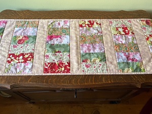 a 100% cotton quilted table runner made with six different floral fabrics