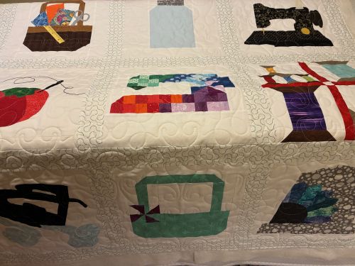 a longarmed and appliqued quilt of sewing motifs