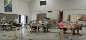 a group of women in a large room making quilts