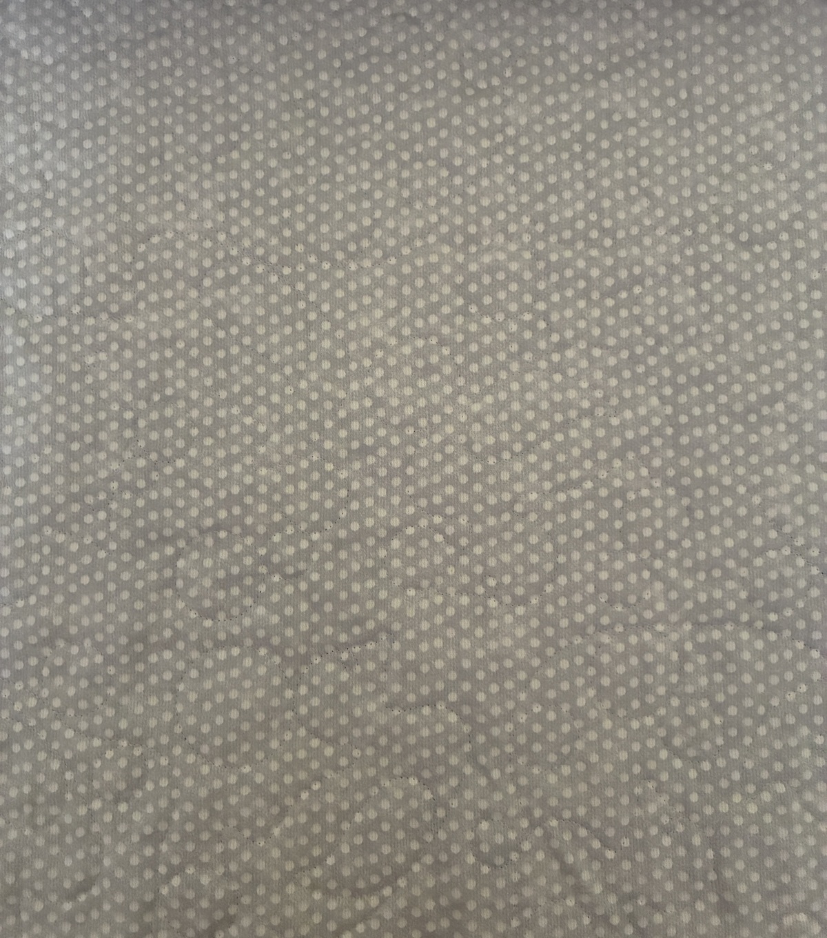 Gray fabric with a pattern of small white polka dots evenly scattered across the surface.