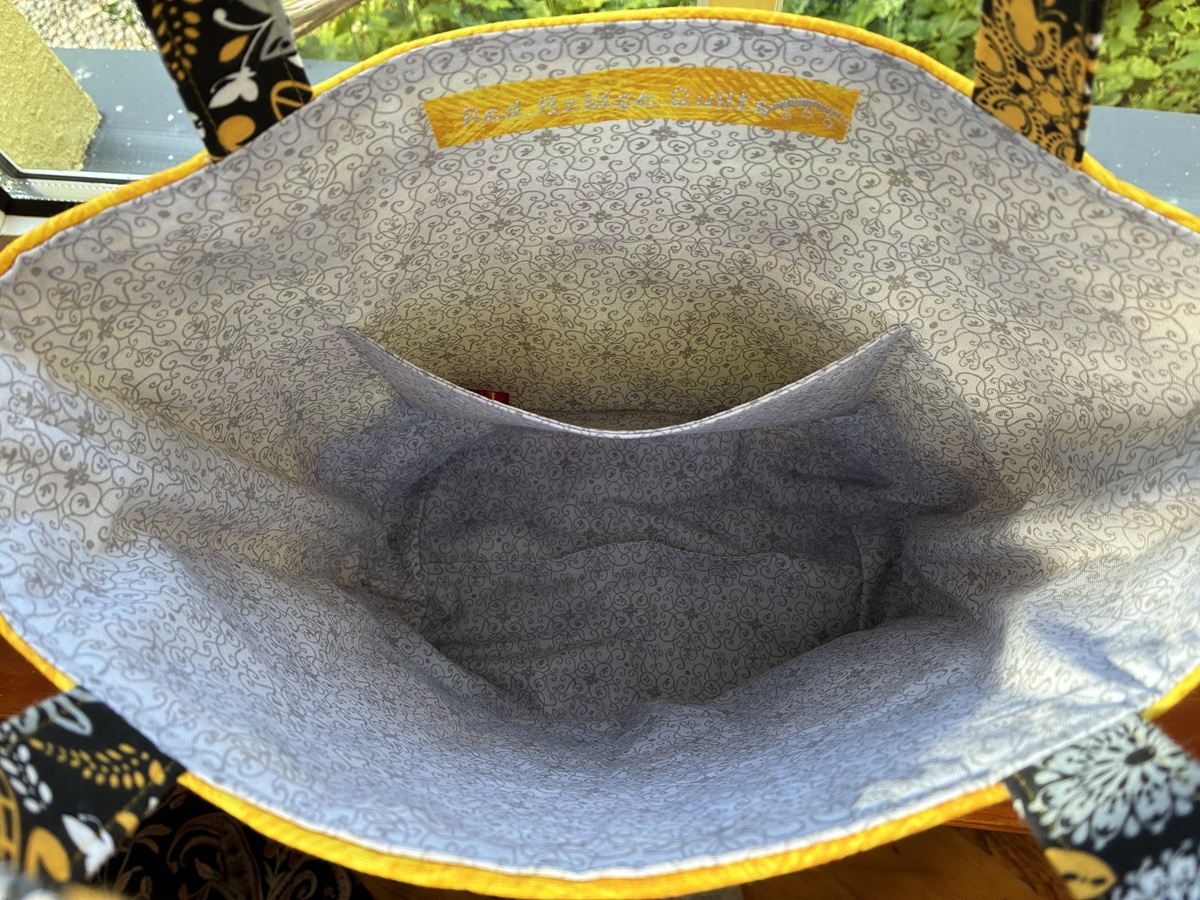 a view of the patterned grey interior of a tote bag with an inside pocket