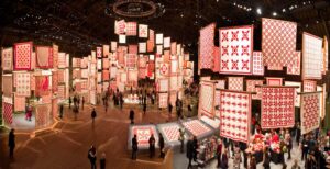 a very large private exhibit of quilts all made in red and white